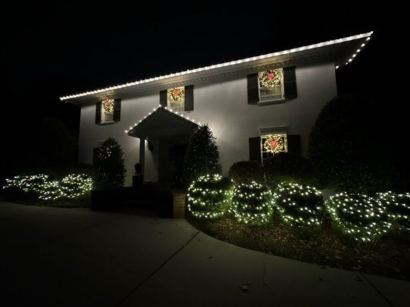 A Charlotte home illuminated with custom holiday lights, showing a dramatic before-and-after transformation that delights neighbors and homeowners alike.