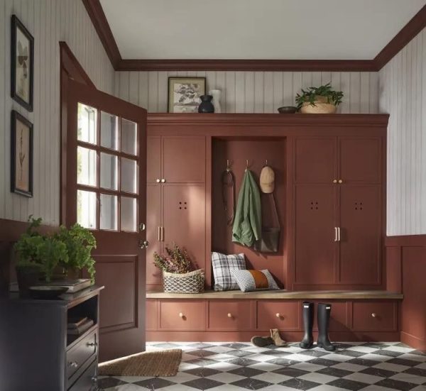 Mudroom with rich earthy cabinetry, organic brown-red tones, plaid pillows, and natural accents