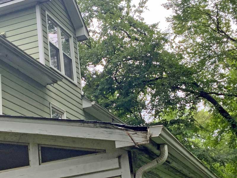 Exterior Home Damage Requiring Repair and Repainting Exterior home with peeling paint and visible surface damage, highlighting areas that need repair and professional repainting.