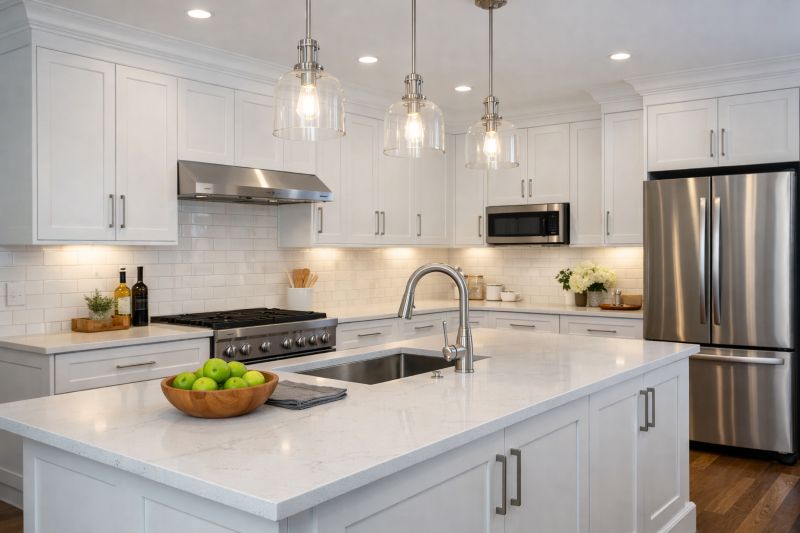 refinished-kitchen-cabinets-factory-smooth-finish Freshly refinished white kitchen cabinets with a smooth, factory-like finish, modern hardware, and quartz countertops in a bright, updated kitchen space.