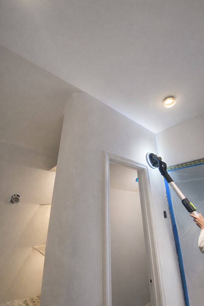 Sanding: Creating a Mechanical Bond | Interior Paint Prep Painter sanding interior wall and doorway during prep work to create a mechanical bond before painting